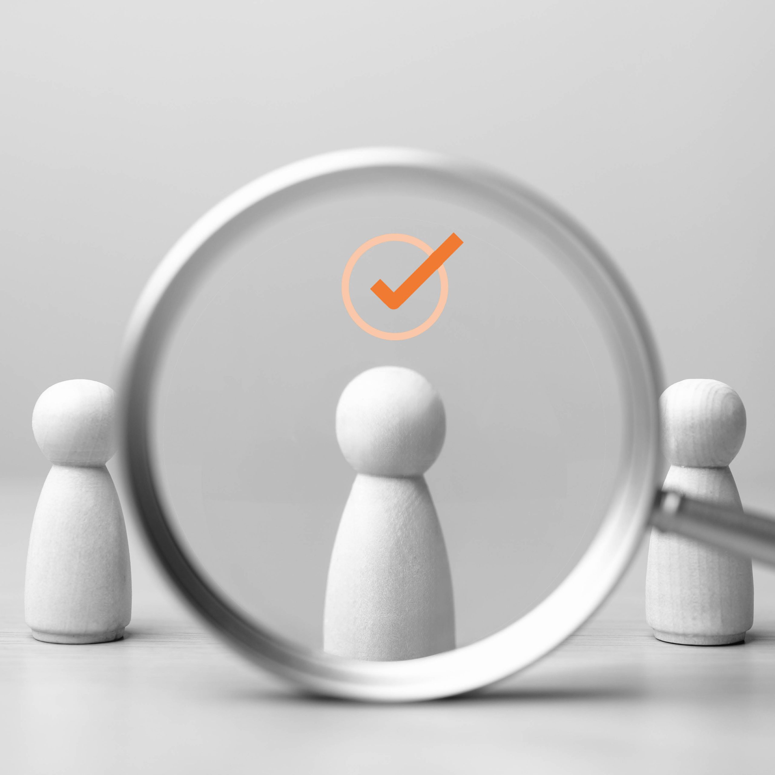 image of a person under a magnifying glass with a check mark above their head